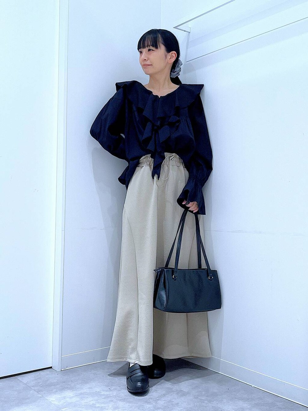 ブラック系のハンドバッグ、ブラック系のローファー、ブラック系のシャツ/ブラウスを着用したレディースの春コーディネートの2枚目の写真