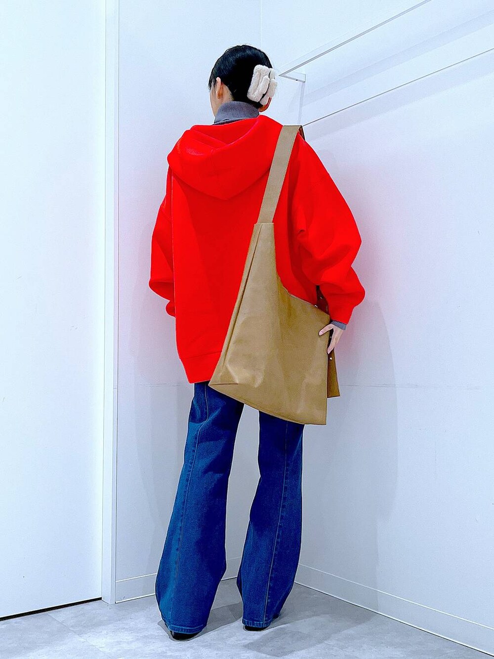 レッド系のパーカー、ブラック系のブーツ、グレー系のニット/セーターを着用したレディースの冬コーディネートの5枚目の写真