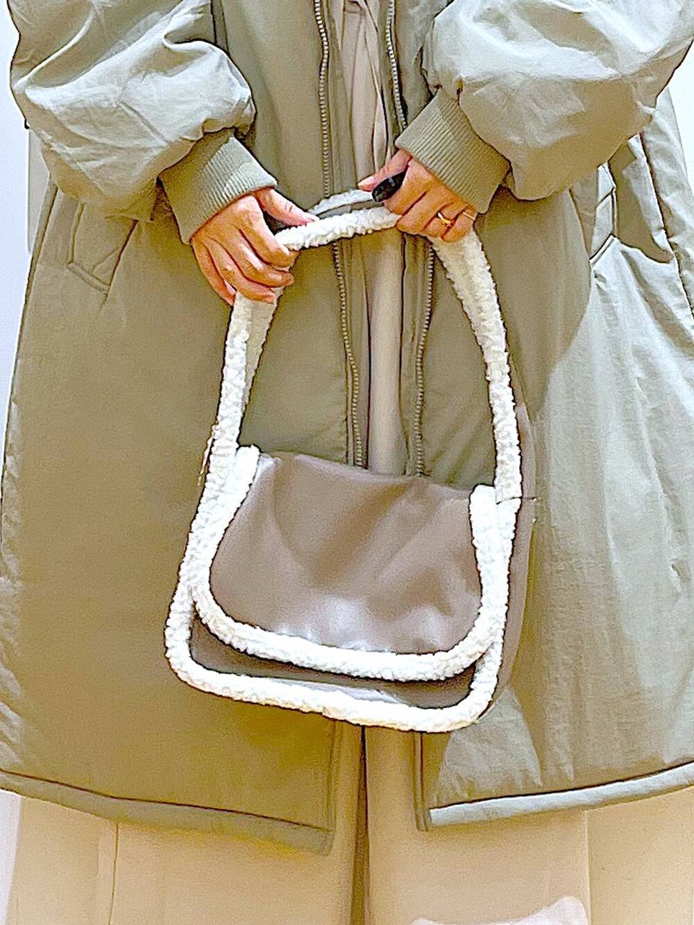 ブラック系のニット/セーター、ベージュ系のショルダーバッグ、ブラック系のブーツを着用したレディースの冬コーディネートの9枚目の写真