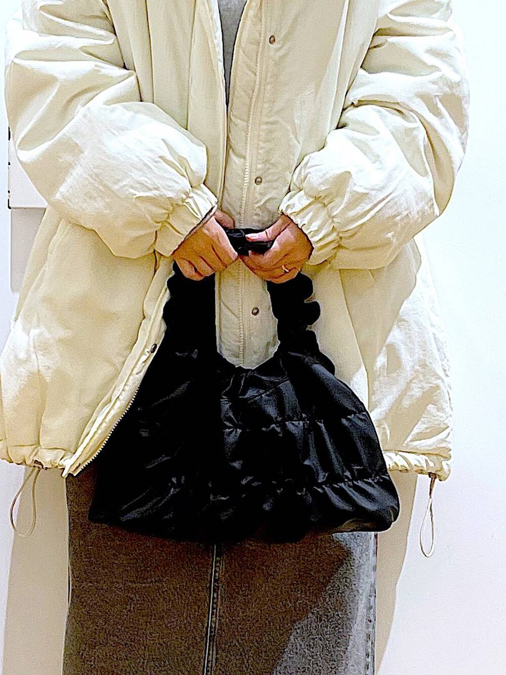 シルバー系のローファー、ホワイト系のその他アウター、ブラック系のショルダーバッグを着用したレディースの冬コーディネートの9枚目の写真