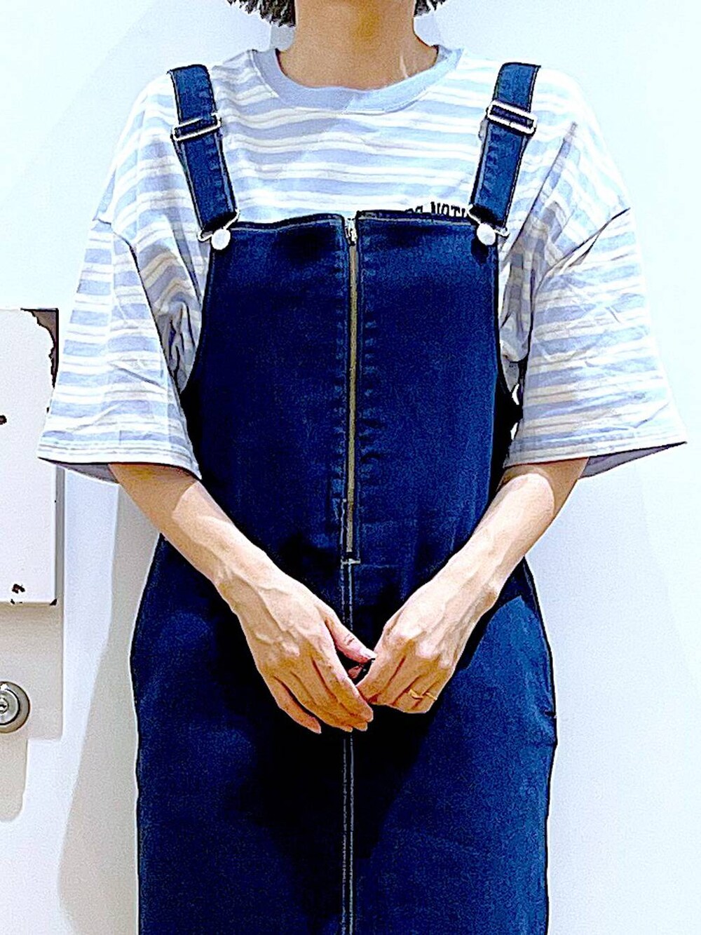 ホワイト系のパンプス、ブルー系のジャンパースカート、ブラック系のショルダーバッグを着用したレディースの夏コーディネートの7枚目の写真