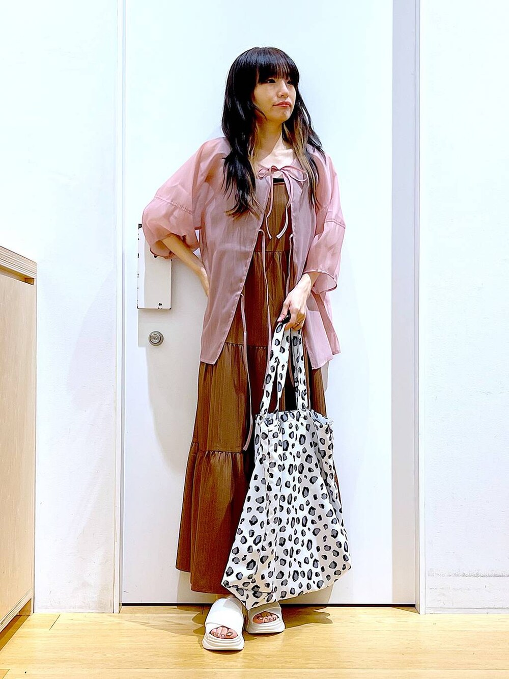 ホワイト系のサンダル、ベージュ系のワンピース、ホワイト系のトートバッグを着用したレディースの夏コーディネートの2枚目の写真