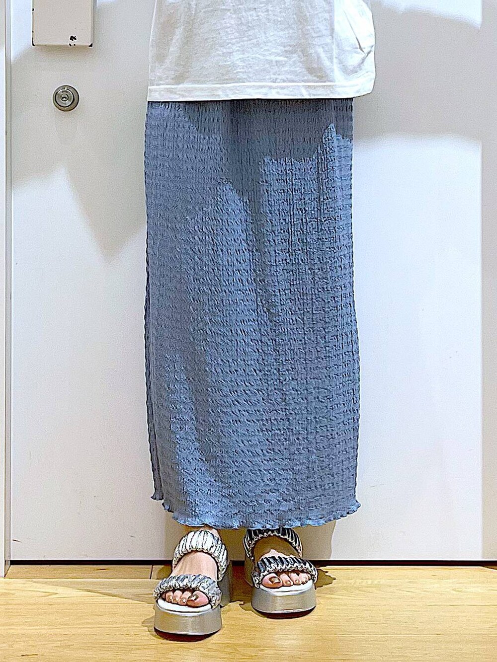 シルバー系のサンダル、ブルー系のスカート、ホワイト系のトートバッグを着用したレディースの夏コーディネートの8枚目の写真