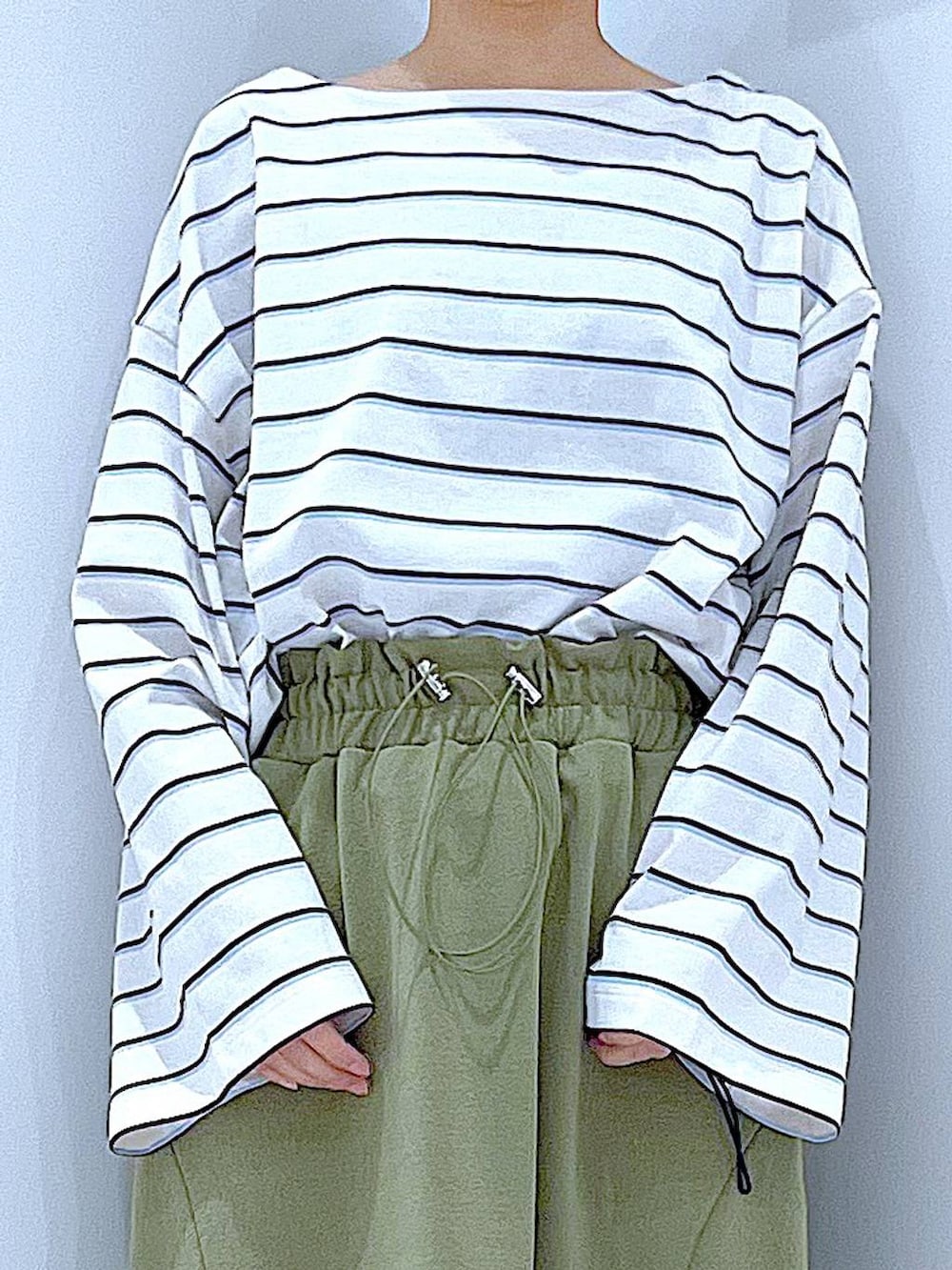 ブラック系のショルダーバッグ、グリーン系のスカート、ホワイト系のTシャツ/カットソーを着用したレディースの冬コーディネートの7枚目の写真