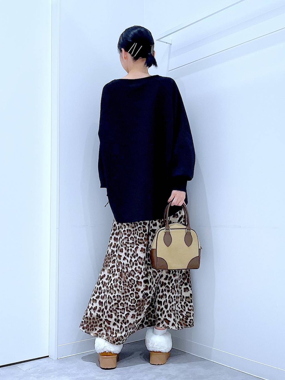 イエロー系のスリッポン、ベージュ系のハンドバッグ、ブラウン系のスカートを着用したレディースの秋コーディネートの5枚目の写真