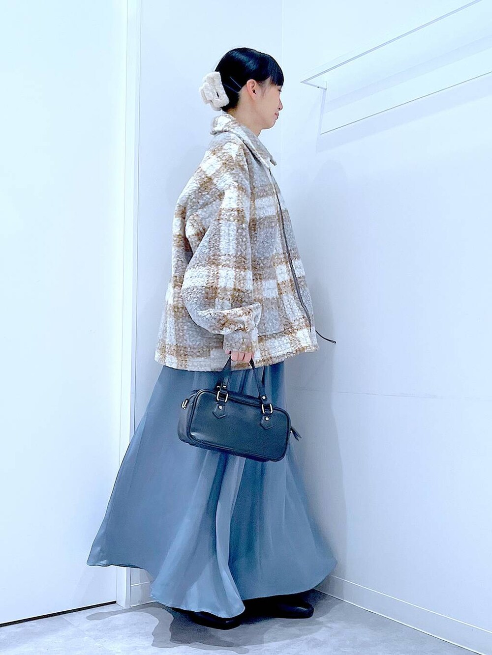 その他のブルゾン、ブラック系のブーツ、ブラック系のショルダーバッグを着用したレディースの秋コーディネートの4枚目の写真