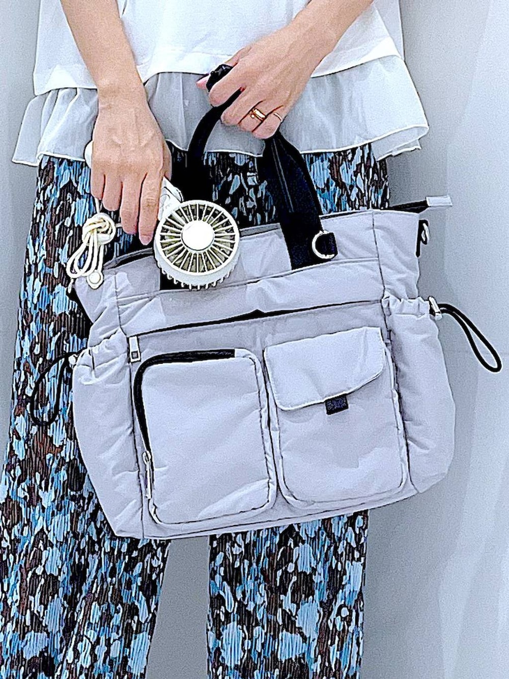 グレー系のトートバッグ、ブラック系のサンダル、ブルー系のその他パンツを着用したレディースの夏コーディネートの9枚目の写真