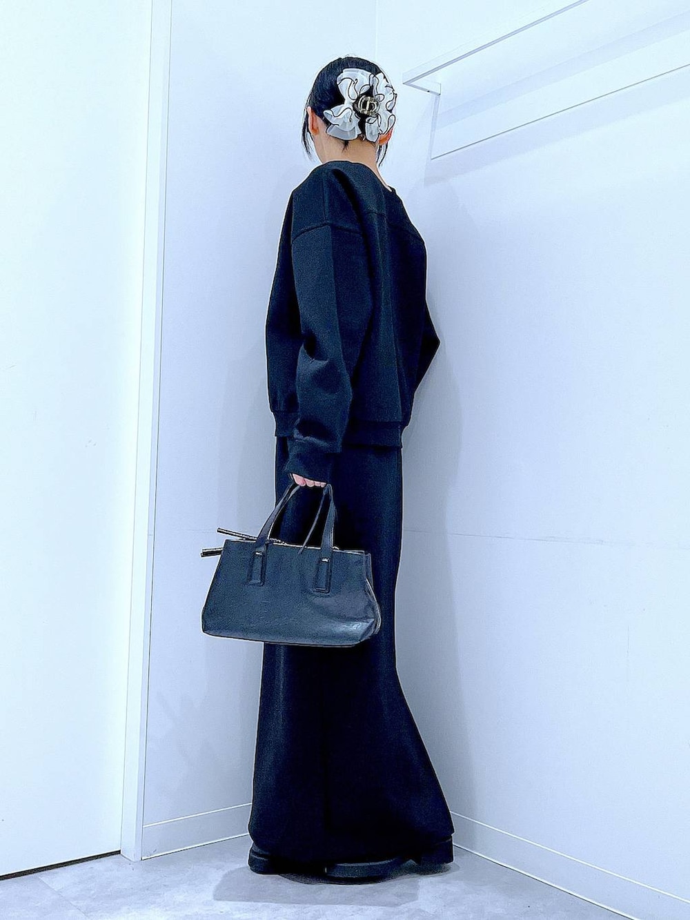 ブラック系のボストンバッグ、ブラック系のスウェット、ブラック系のスカートを着用したレディースの春コーディネートの3枚目の写真