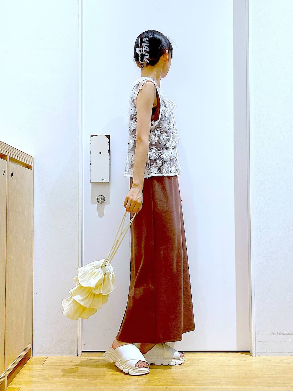 ホワイト系のサンダル、レッド系のワンピース、ホワイト系のベストを着用したレディースの夏コーディネートの4枚目の写真