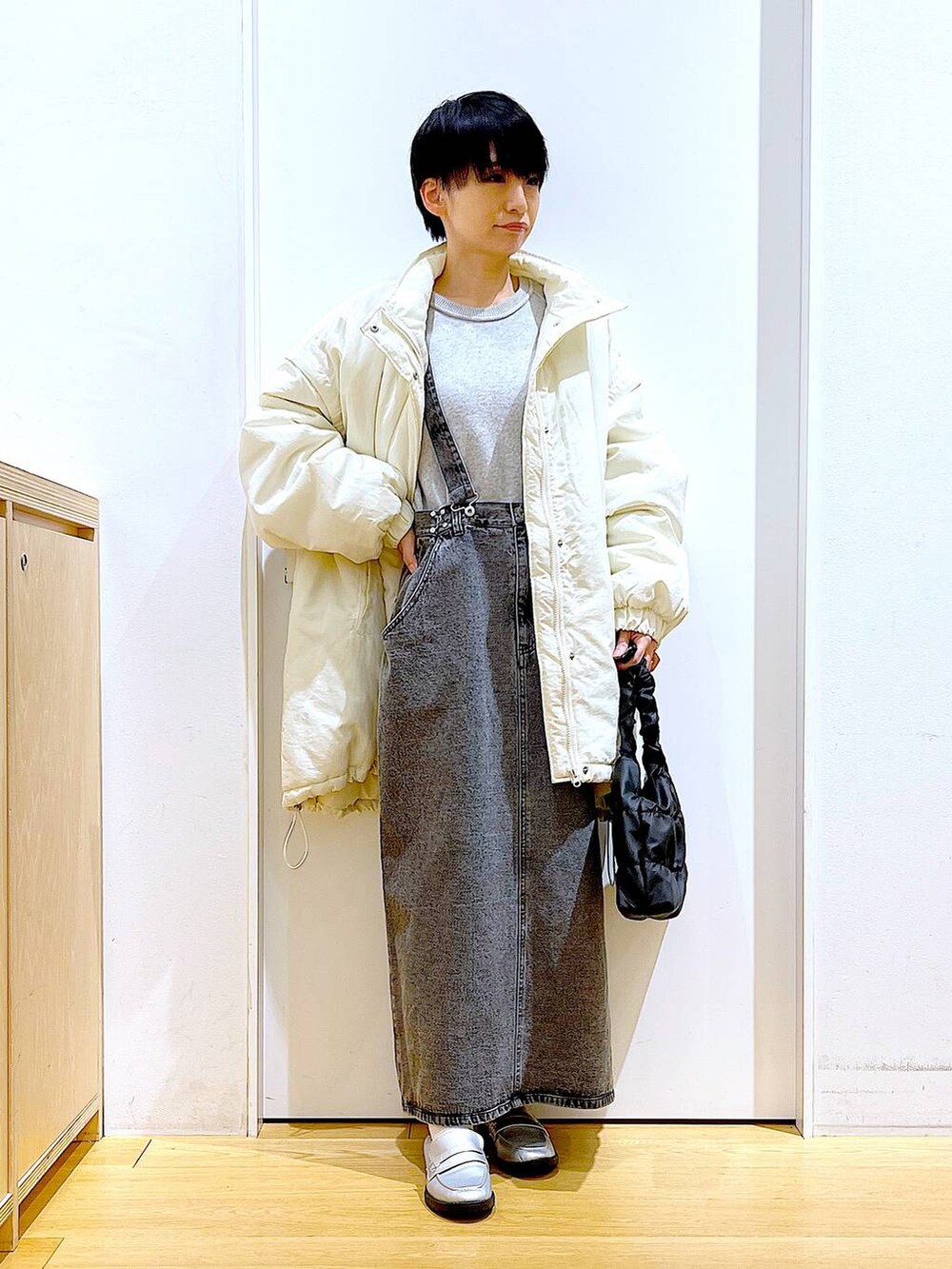 シルバー系のローファー、ホワイト系のその他アウター、ブラック系のショルダーバッグを着用したレディースの冬コーディネートの2枚目の写真