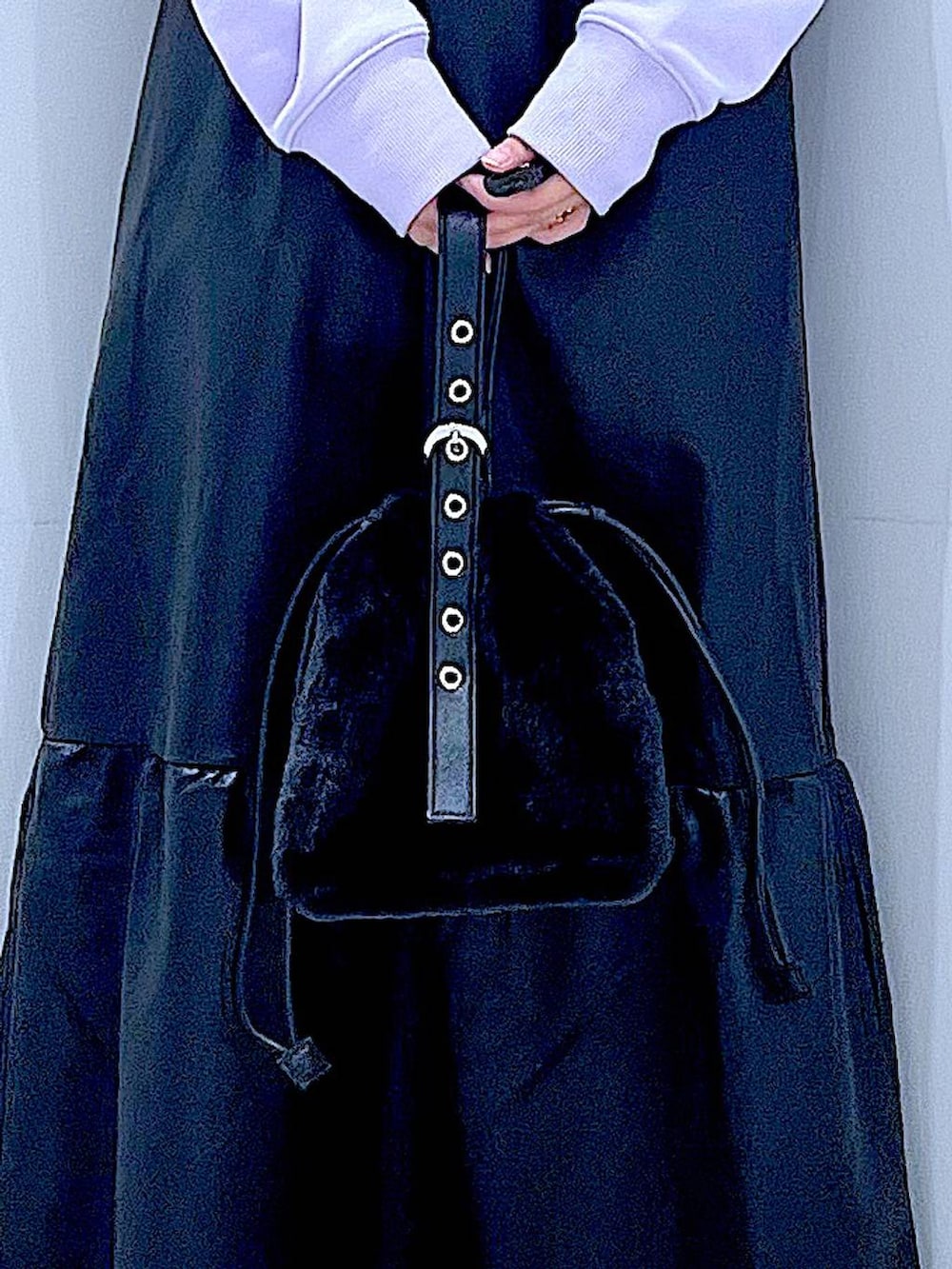 ブラック系のハンドバッグ、ブラック系のブーツ、パープル系のスウェットを着用したレディースの冬コーディネートの9枚目の写真