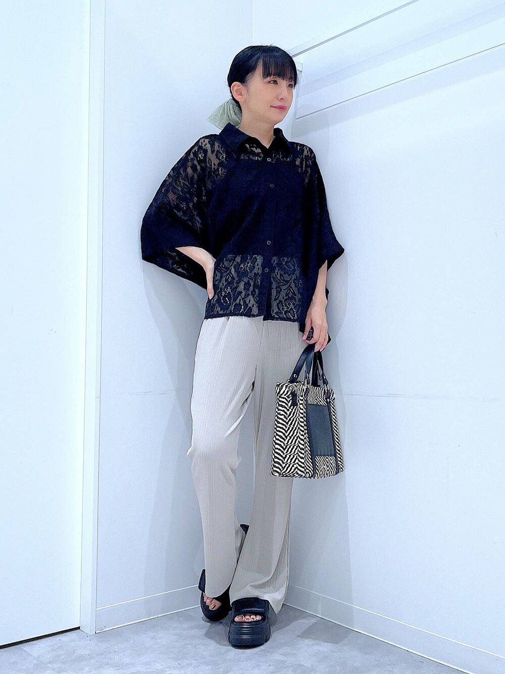 ベージュ系のその他パンツ、その他のショルダーバッグ、ブラック系のサンダルを着用したレディースの夏コーディネートの2枚目の写真