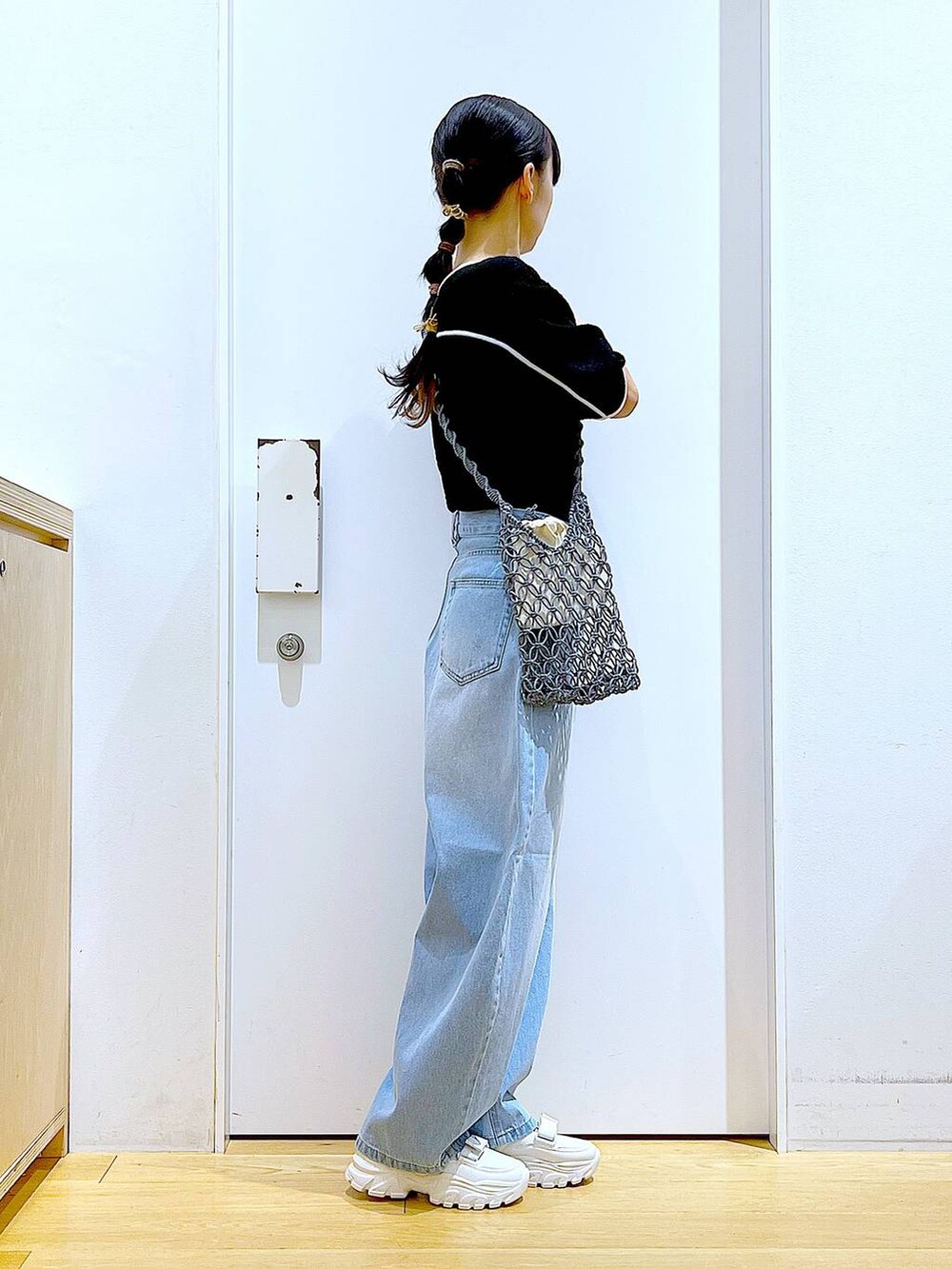 ホワイト系のスニーカー、ブルー系のデニムパンツ、グレー系のショルダーバッグを着用したレディースの夏コーディネートの4枚目の写真