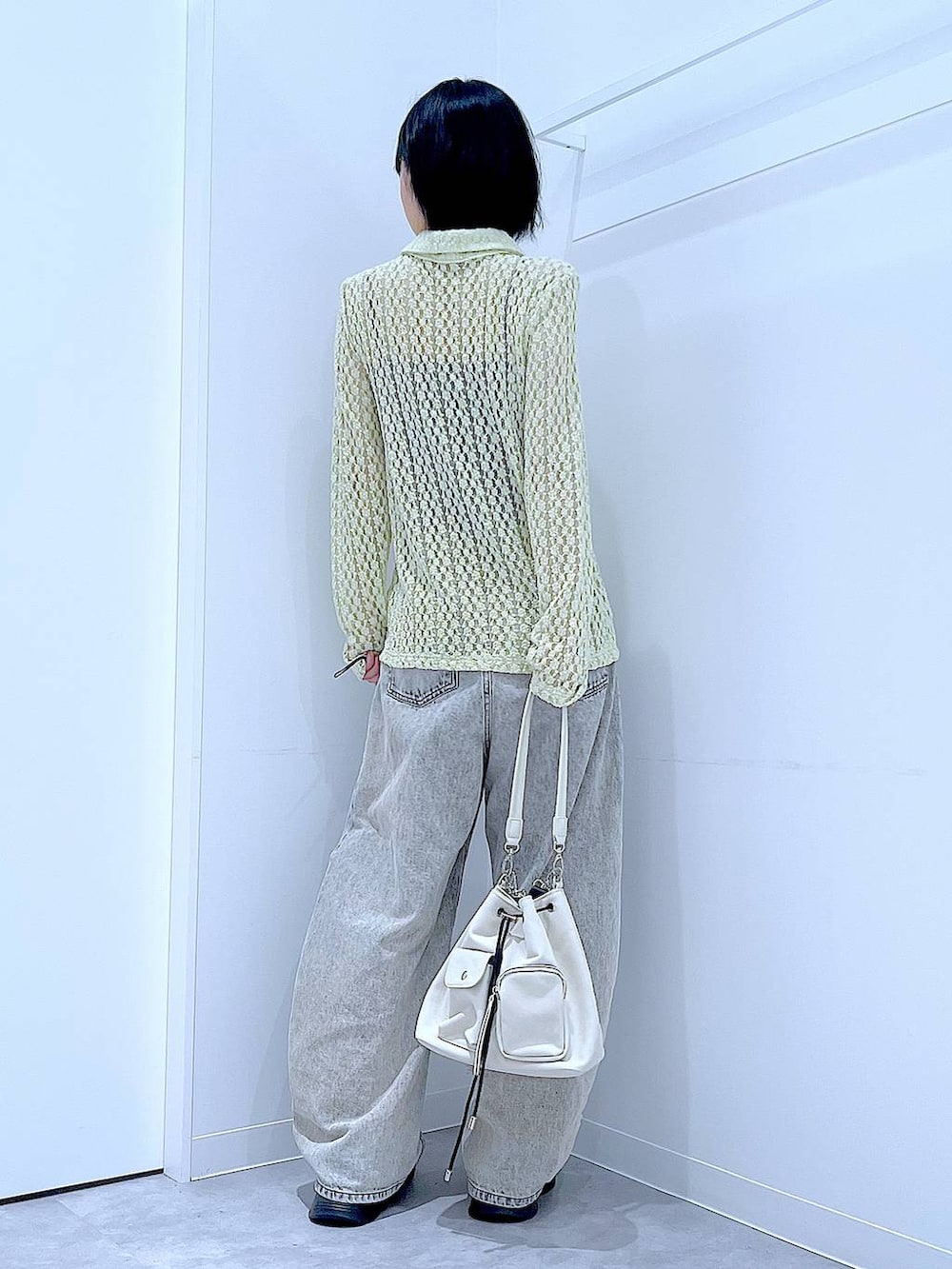 ベージュ系のデニムパンツ、ホワイト系のローファー、ホワイト系のショルダーバッグを着用したレディースの秋コーディネートの5枚目の写真