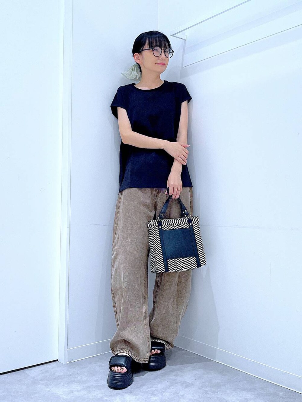 ブラウン系のデニムパンツ、その他のショルダーバッグ、ブラック系のサンダルを着用したレディースの夏コーディネートの2枚目の写真