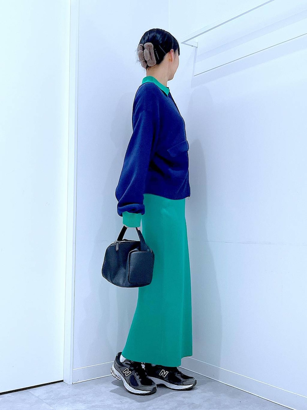 ブラック系のショルダーバッグ、ブルー系のカーディガン/ボレロ、グリーン系のスカートを着用したレディースの春コーディネートの4枚目の写真