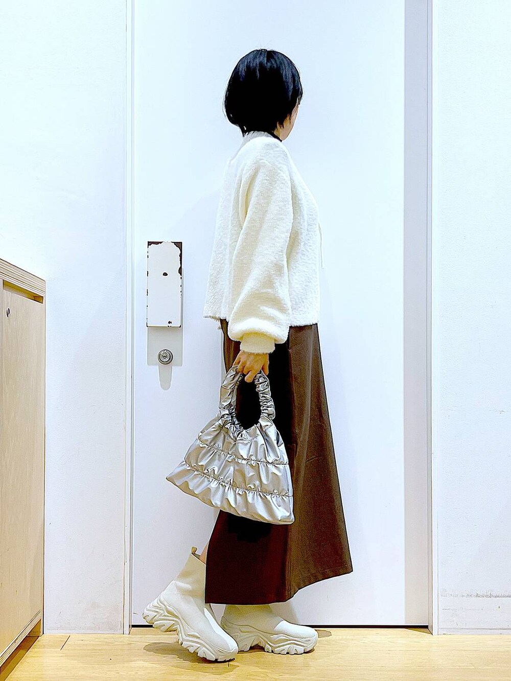 ベージュ系のニット/セーター、ベージュ系のブーツ、ブラウン系のサロペット/オーバーオールを着用したレディースの冬コーディネートの4枚目の写真