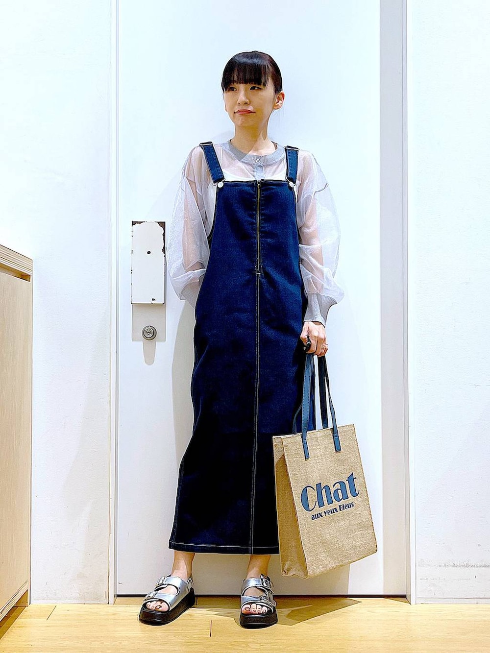 ブルー系のジャンパースカート、ブルー系のトートバッグ、シルバー系のサンダルを着用したレディースの夏コーディネートの2枚目の写真