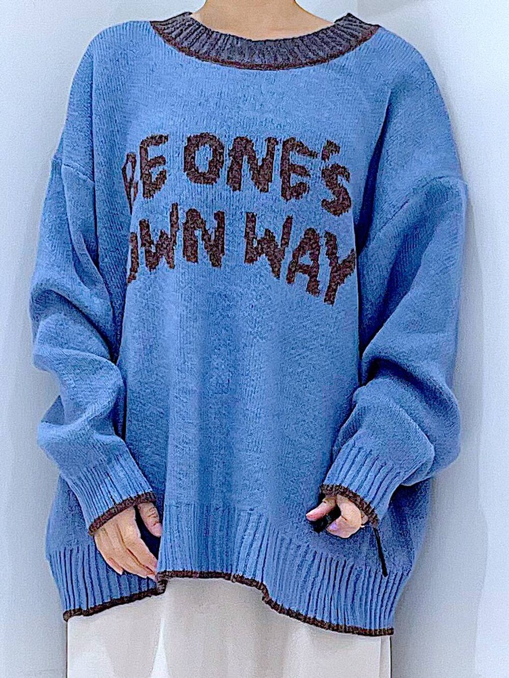 ベージュ系のスカート、ブラック系のブーツ、ホワイト系のショルダーバッグを着用したレディースの冬コーディネートの7枚目の写真