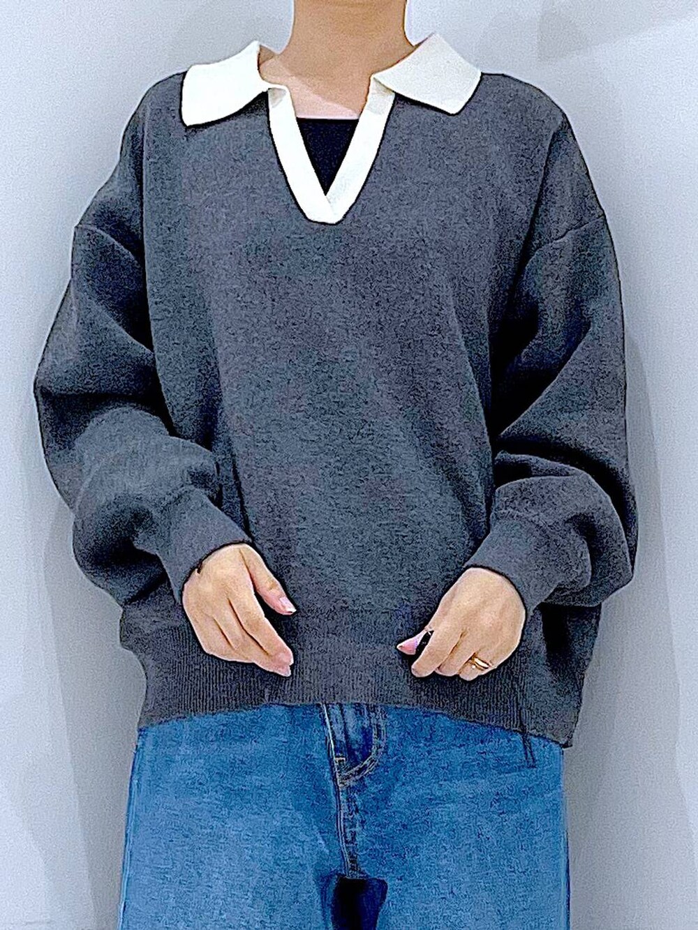 ブルー系のデニムパンツ、レッド系のショルダーバッグ、グレー系のニット/セーターを着用したレディースの秋コーディネートの7枚目の写真