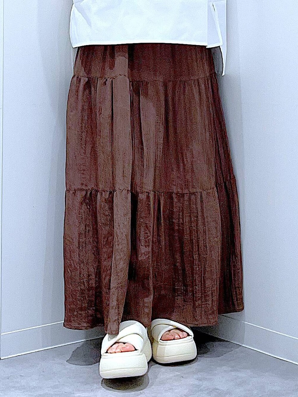 ホワイト系のサンダル、ホワイト系のTシャツ/カットソー、ブラウン系のスカートを着用したレディースの夏コーディネートの8枚目の写真