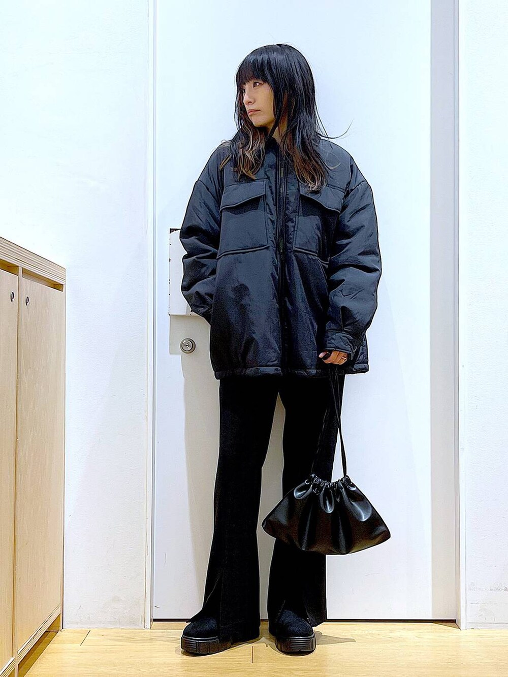 ブラック系のブルゾン、ブラック系のショルダーバッグ、ブラック系のブーツを着用したレディースの冬コーディネートの2枚目の写真