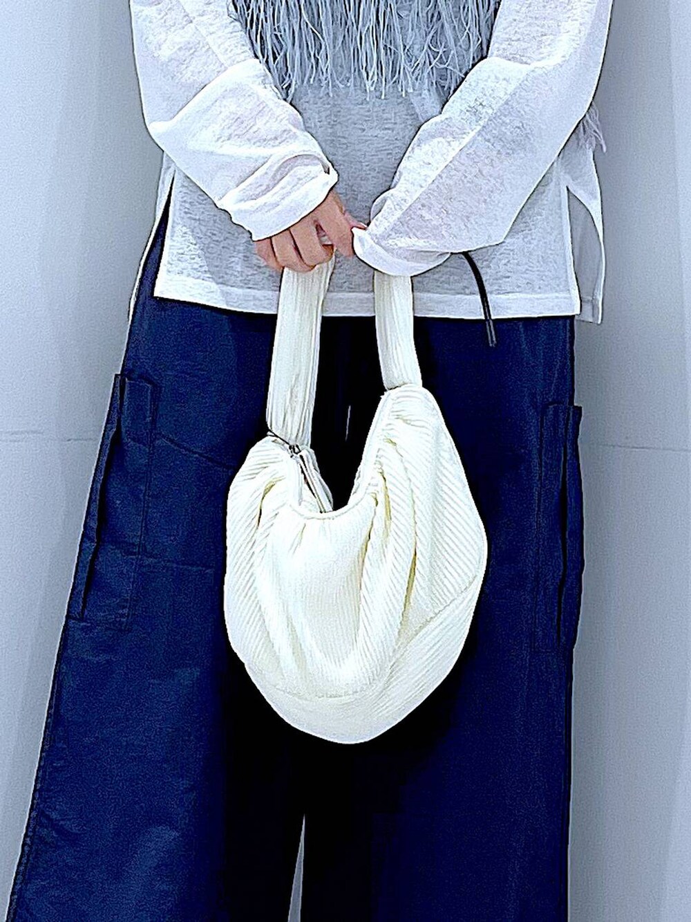 ブルー系のベスト、ホワイト系のショルダーバッグ、ホワイト系のTシャツ/カットソーを着用したレディースの春コーディネートの9枚目の写真