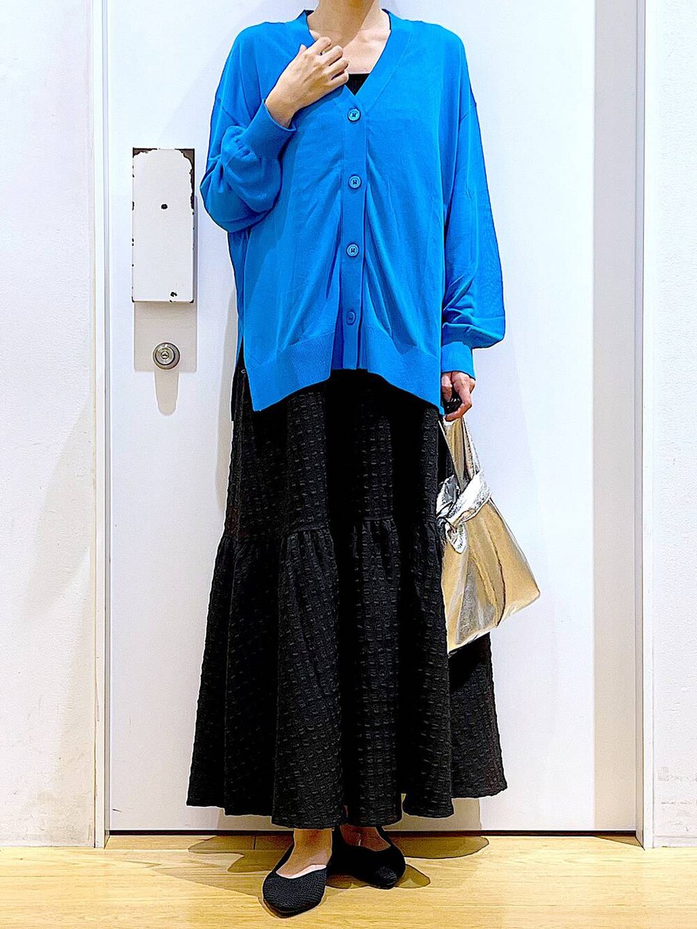 シルバー系のショルダーバッグ、ブラック系のワンピース、ブラック系のパンプスを着用したレディースの春コーディネートの6枚目の写真