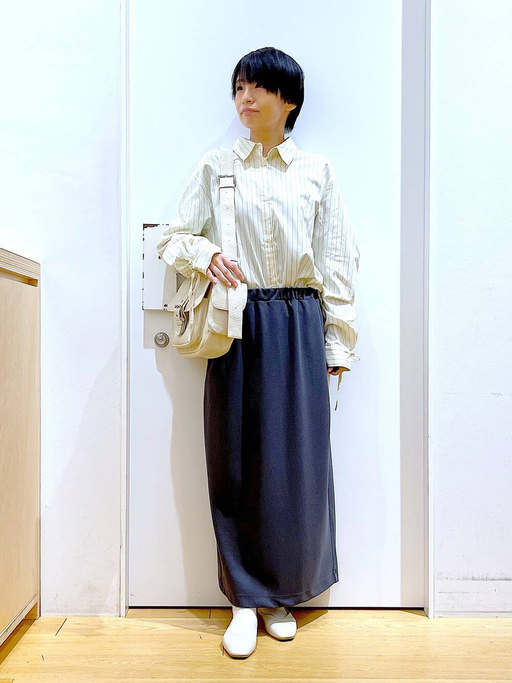 ホワイト系のパンプス、ベージュ系のシャツ/ブラウス、グレー系のスカートを着用したレディースの春コーディネートの2枚目の写真