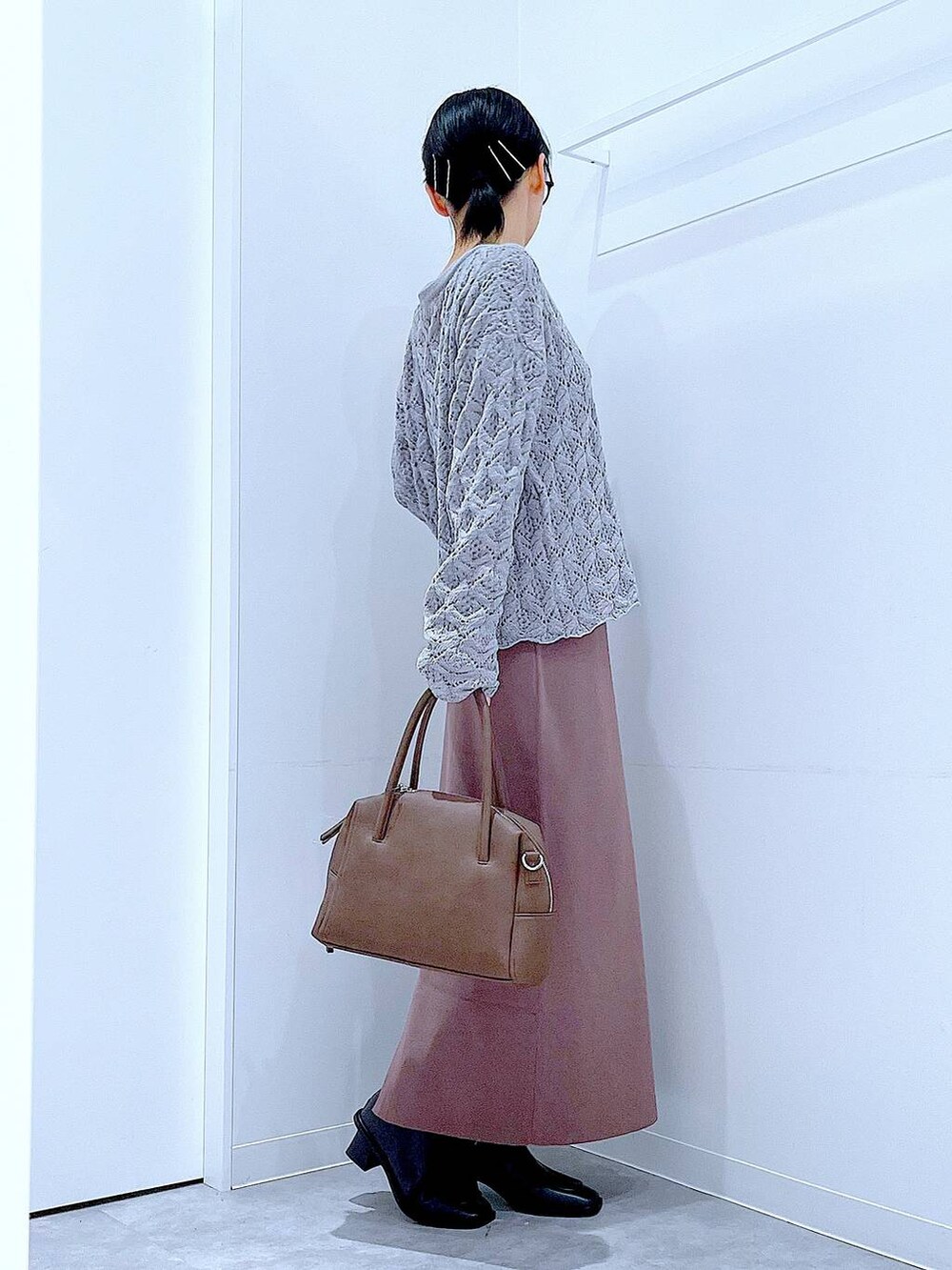 ブラウン系のボストンバッグ、ブラック系のブーツ、グレー系のカーディガン/ボレロを着用したレディースの冬コーディネートの4枚目の写真