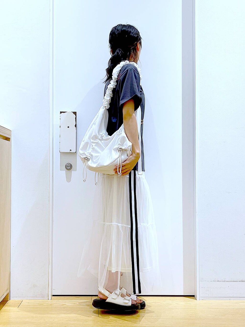 ホワイト系のサンダル、ホワイト系のショルダーバッグ、ホワイト系のスカートを着用したレディースの夏コーディネートの5枚目の写真