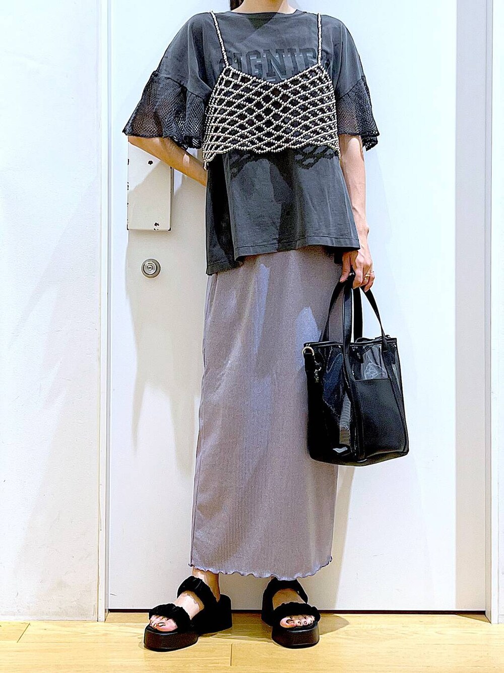 パープル系のスカート、ブラック系のサンダル、ブラック系のトートバッグを着用したレディースの夏コーディネートの6枚目の写真