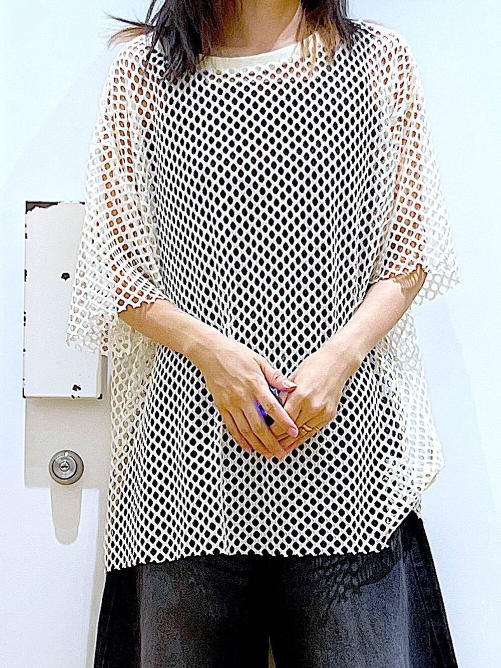 ホワイト系のハンドバッグ、ブラック系のニット/セーター、ホワイト系のTシャツ/カットソーを着用したレディースの夏コーディネートの7枚目の写真