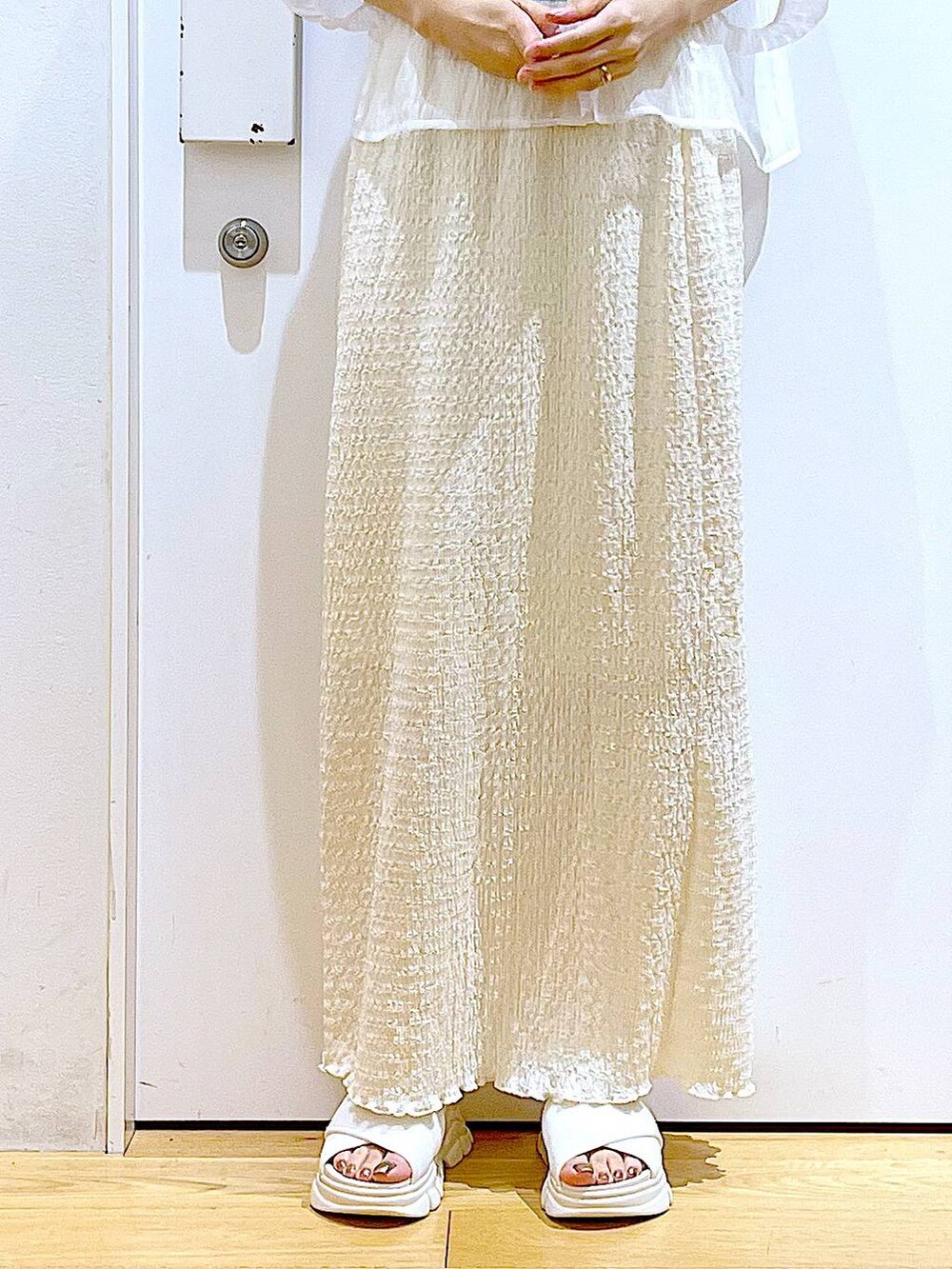 ホワイト系のサンダル、ブラック系のニット/セーター、ブルー系のトートバッグを着用したレディースの夏コーディネートの8枚目の写真