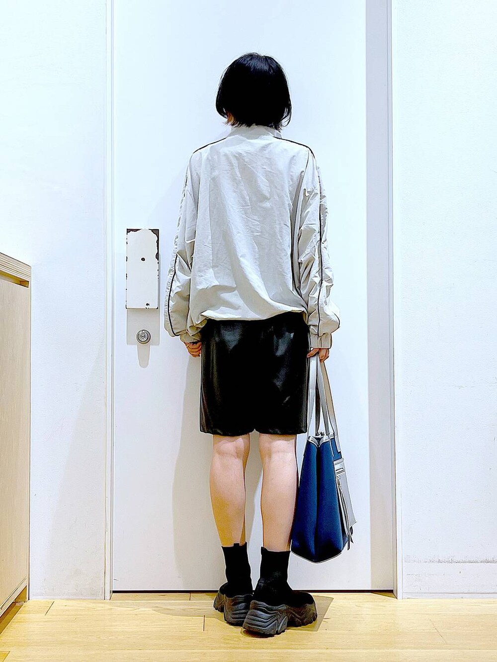 ブラック系のブーツ、ブルー系のトートバッグ、グレー系のブルゾンを着用したレディースの冬コーディネートの5枚目の写真