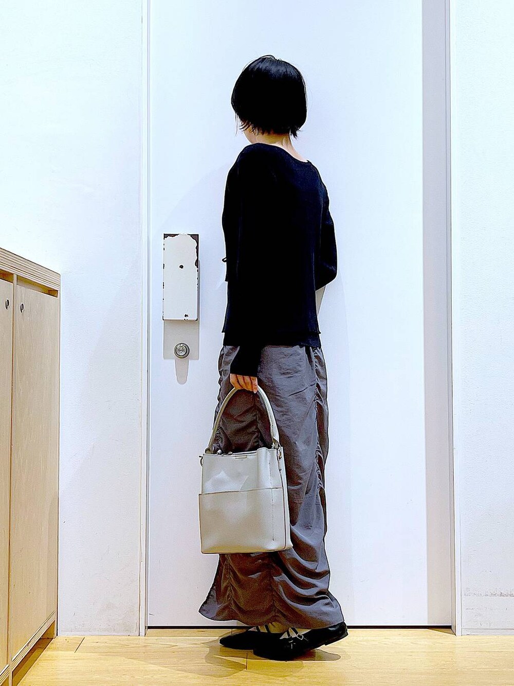 ブラック系のパンプス、ブラック系のカーディガン/ボレロ、グレー系のショルダーバッグを着用したレディースの秋コーディネートの3枚目の写真