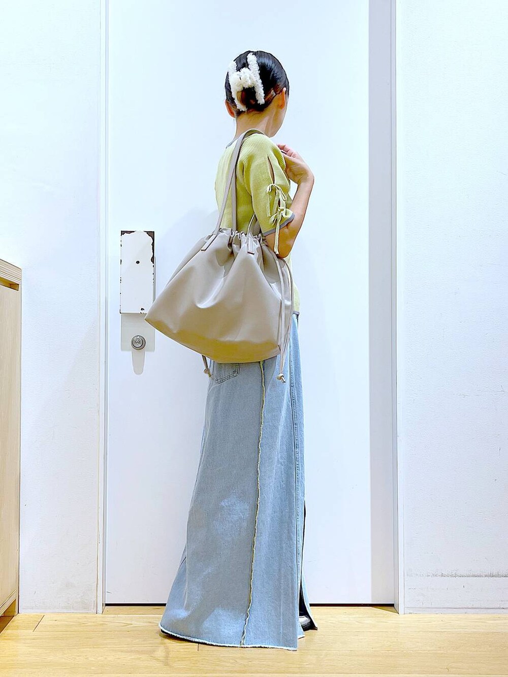 ベージュ系のトートバッグ、シルバー系のローファー、イエロー系のニット/セーターを着用したレディースの秋コーディネートの4枚目の写真