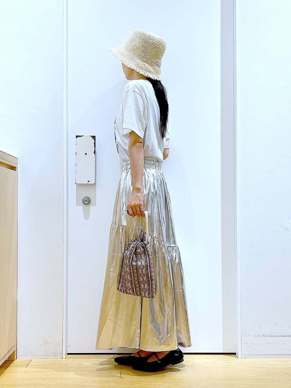 ピンク系のショルダーバッグ、シルバー系のスカート、ホワイト系のTシャツ/カットソーを着用したレディースの夏コーディネートの3枚目の写真