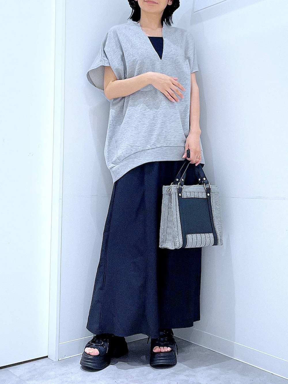 グレー系のショルダーバッグ、ブラック系のサンダル、グレー系のTシャツ/カットソーを着用したレディースの夏コーディネートの6枚目の写真
