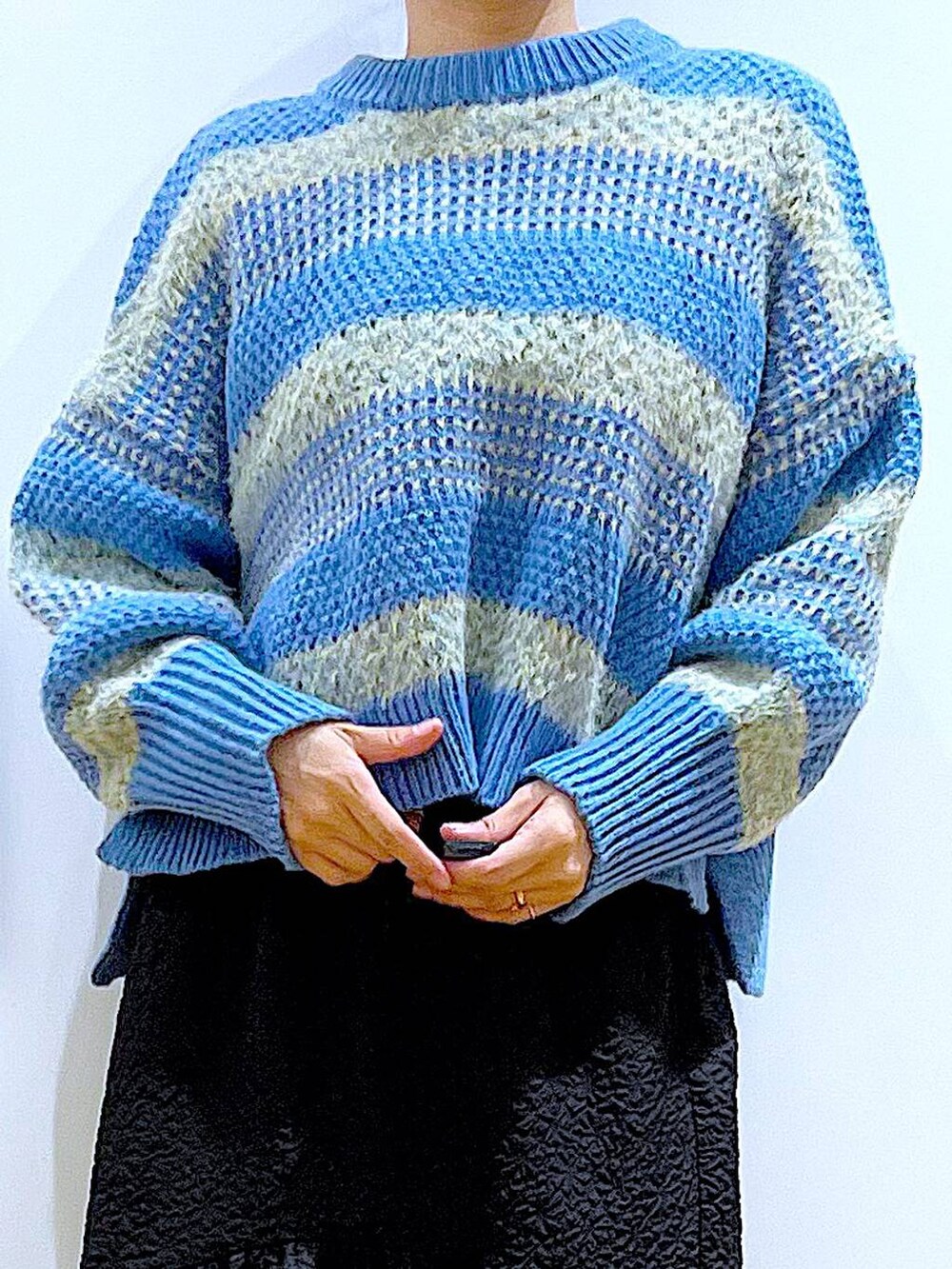 ホワイト系のショルダーバッグ、ブラック系のブーツ、ブラック系のスカートを着用したレディースの冬コーディネートの7枚目の写真