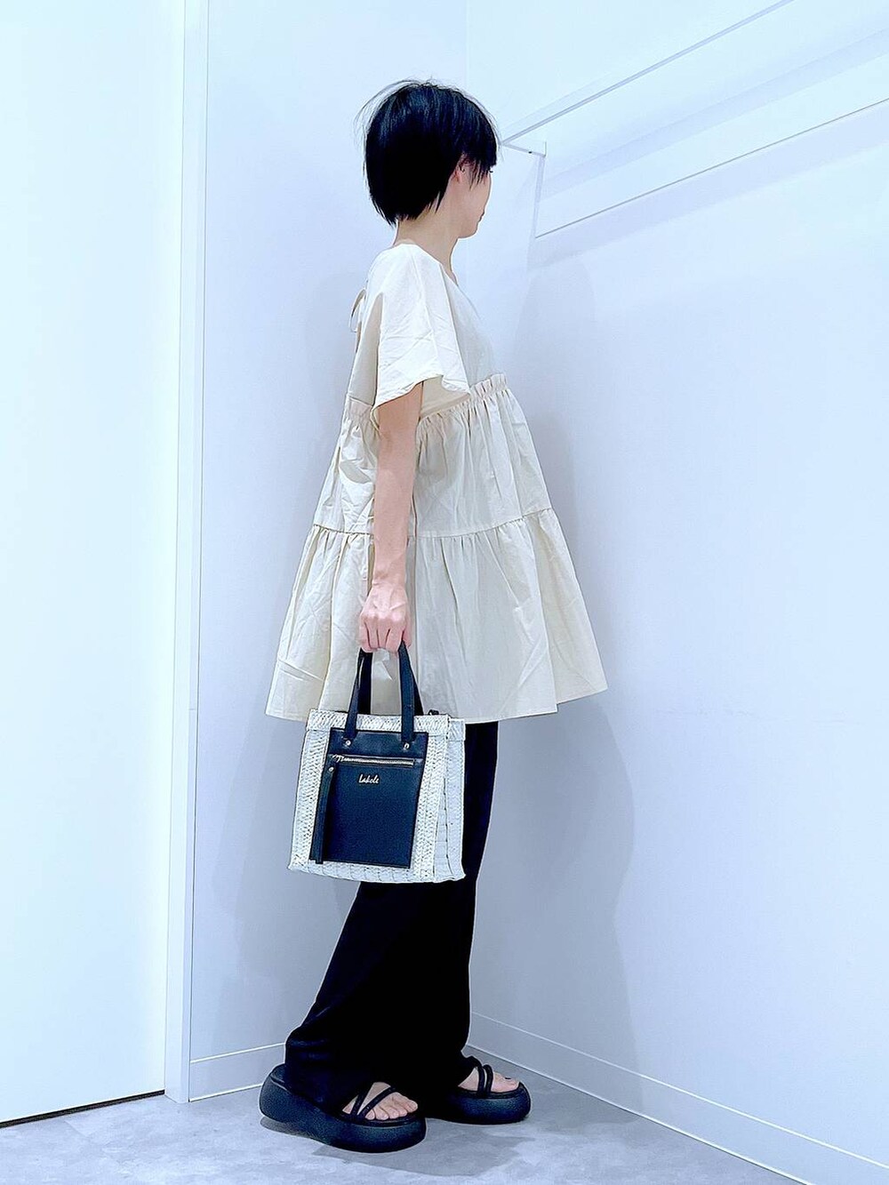 ホワイト系のショルダーバッグ、ブラック系のサンダル、ブラック系のその他パンツを着用したレディースの夏コーディネートの4枚目の写真