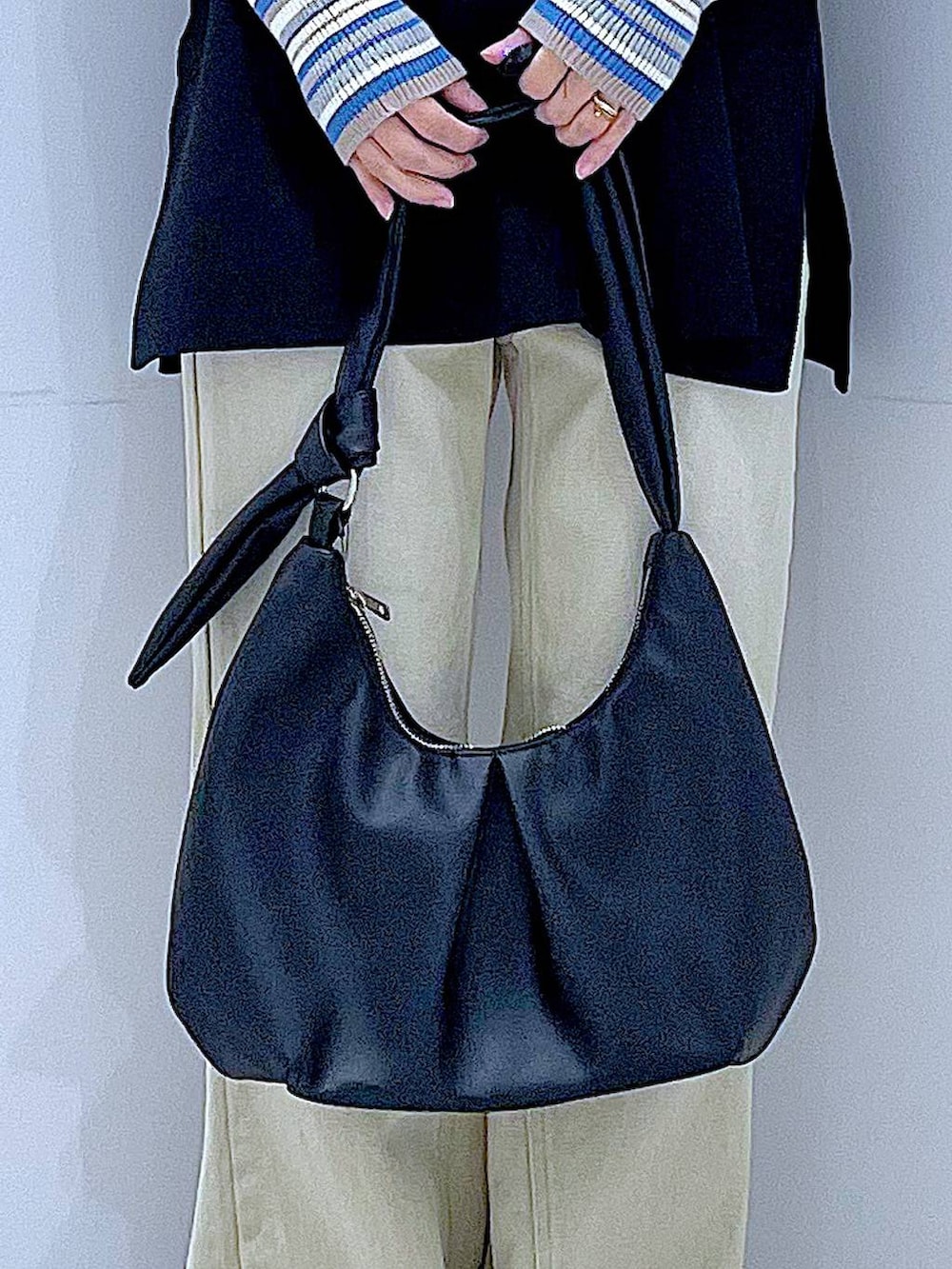 ブルー系のニット/セーター、ブラック系のベスト、ベージュ系のデニムパンツを着用したレディースの冬コーディネートの9枚目の写真