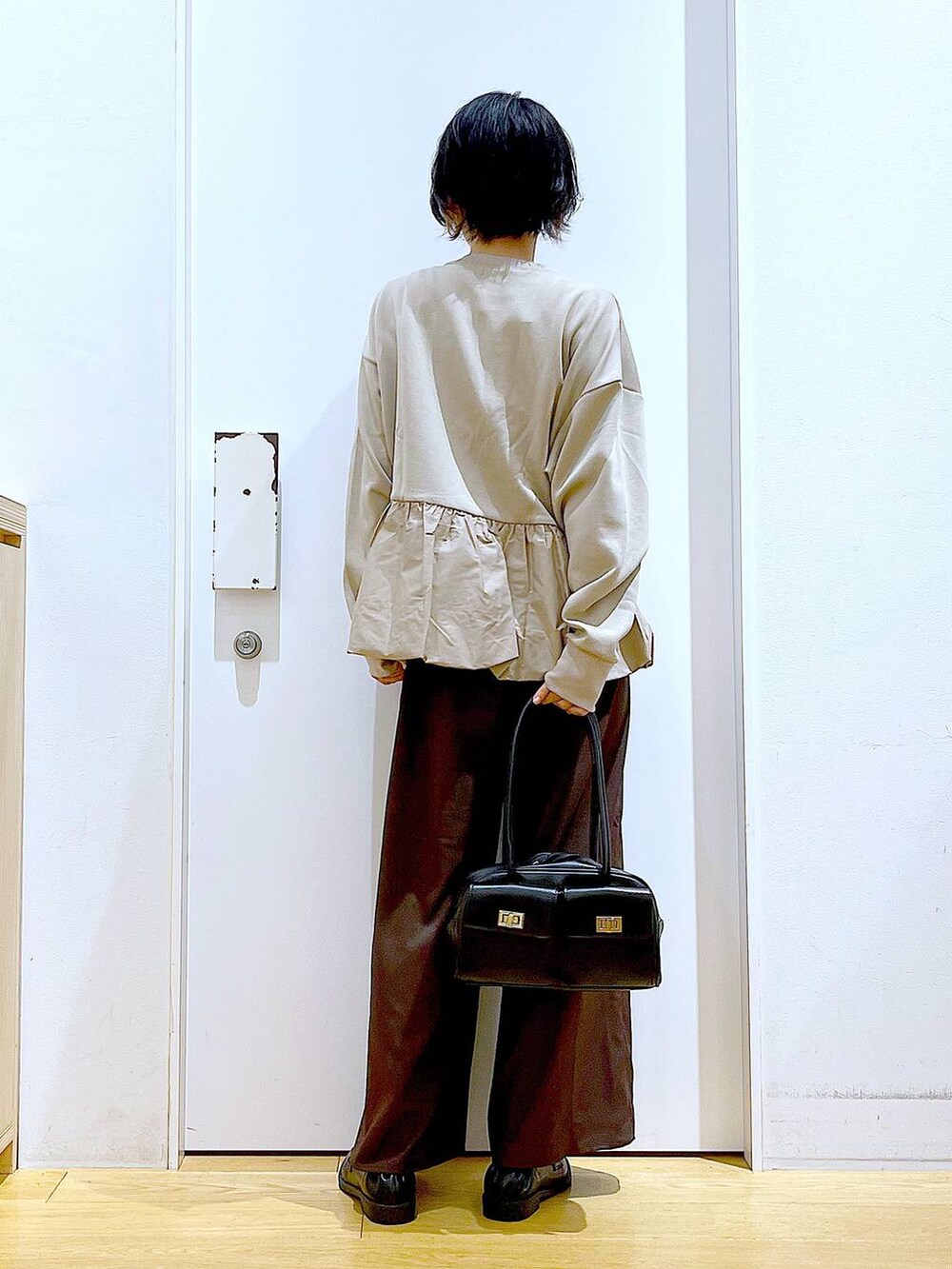 ブラック系のハンドバッグ、ブラウン系のその他パンツ、ブラック系のローファーを着用したレディースの秋コーディネートの5枚目の写真