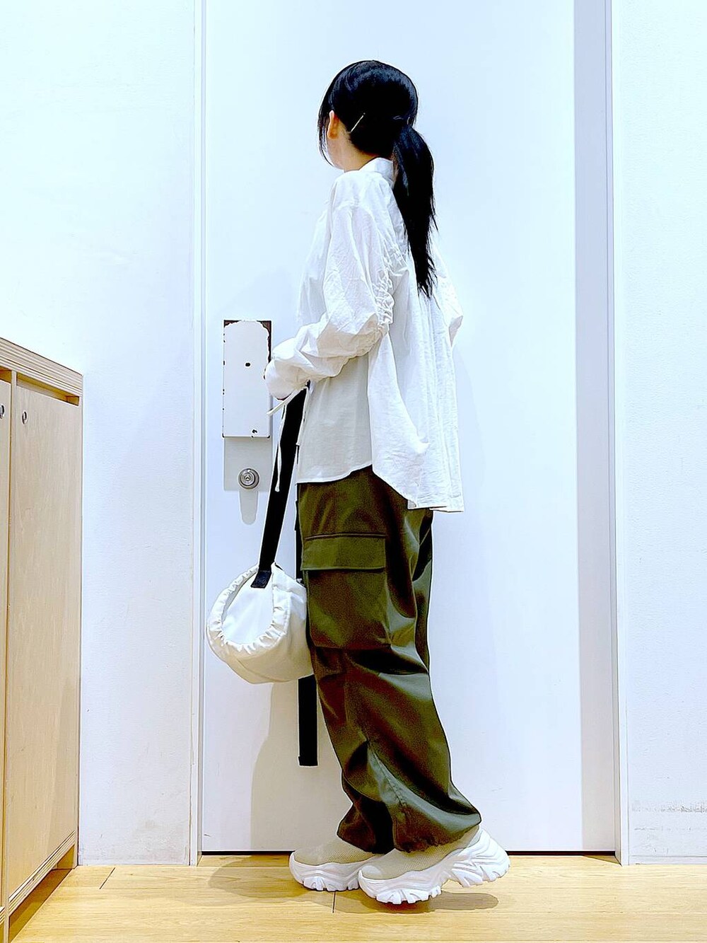 ホワイト系のシャツ/ブラウス、ホワイト系のショルダーバッグ、ベージュ系のスニーカーを着用したレディースの春コーディネートの3枚目の写真