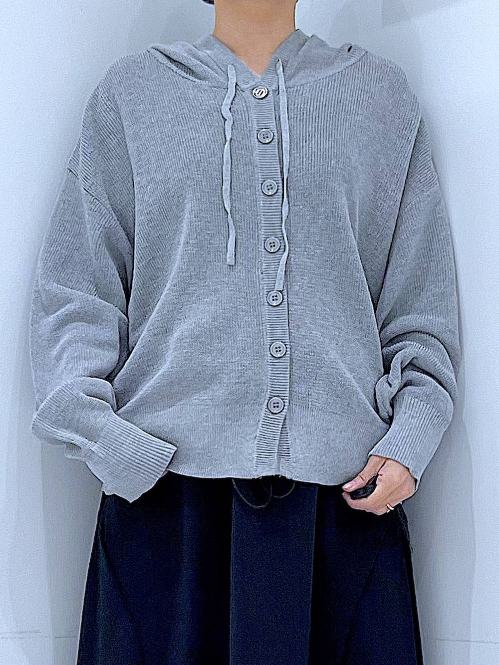 ホワイト系のショルダーバッグ、ブラック系のスカート、グレー系のカーディガン/ボレロを着用したレディースの春コーディネートの7枚目の写真