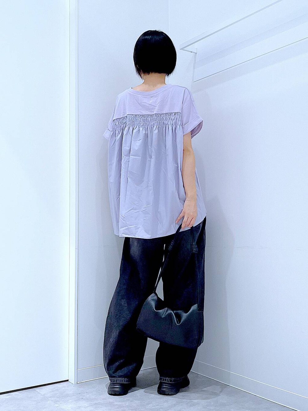 ブラック系のデニムパンツ、ブラック系のスニーカー、パープル系のTシャツ/カットソーを着用したレディースの夏コーディネートの5枚目の写真