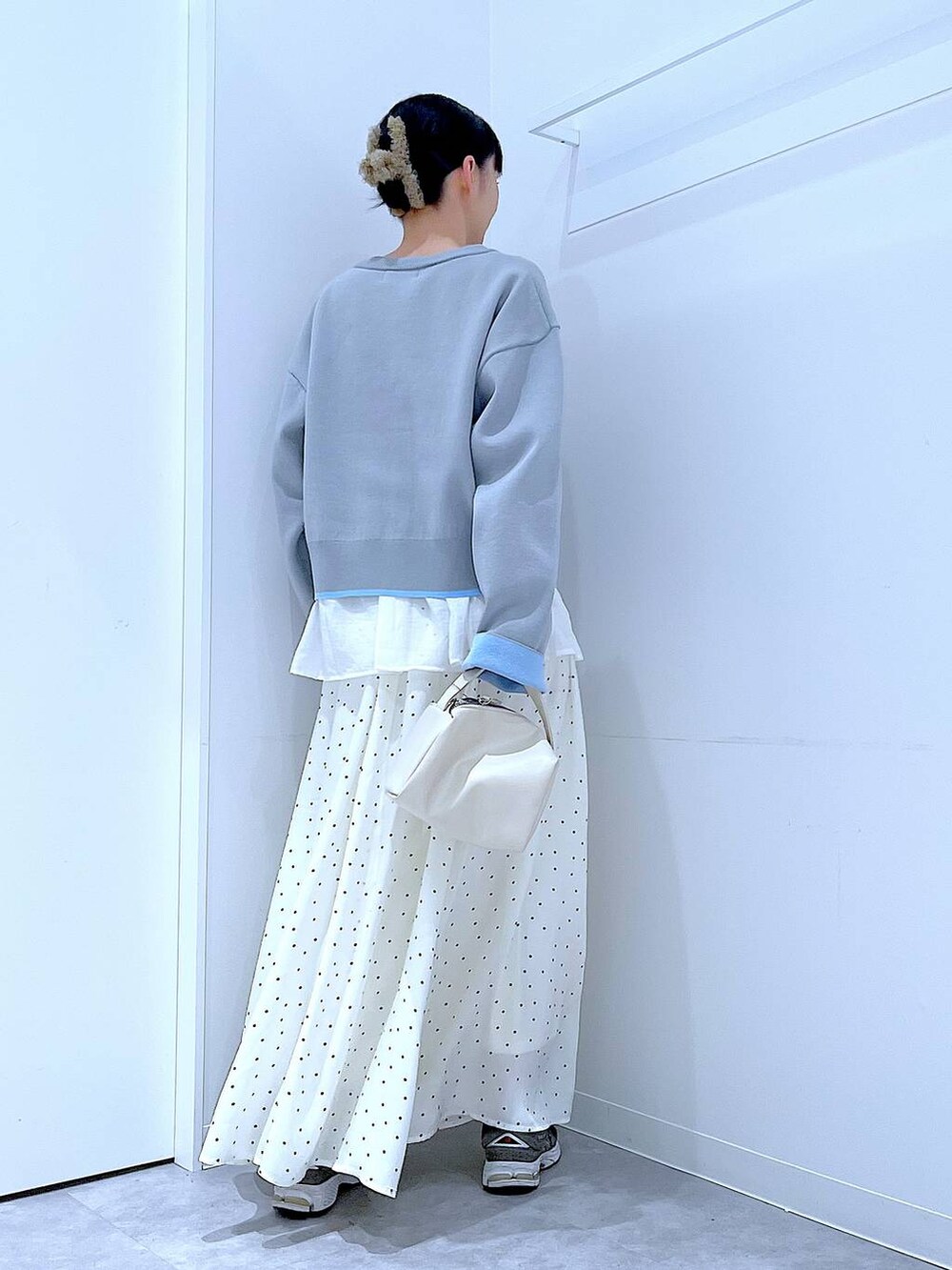 ホワイト系のショルダーバッグ、グレー系のカーディガン/ボレロ、ホワイト系のスカートを着用したレディースの春コーディネートの5枚目の写真