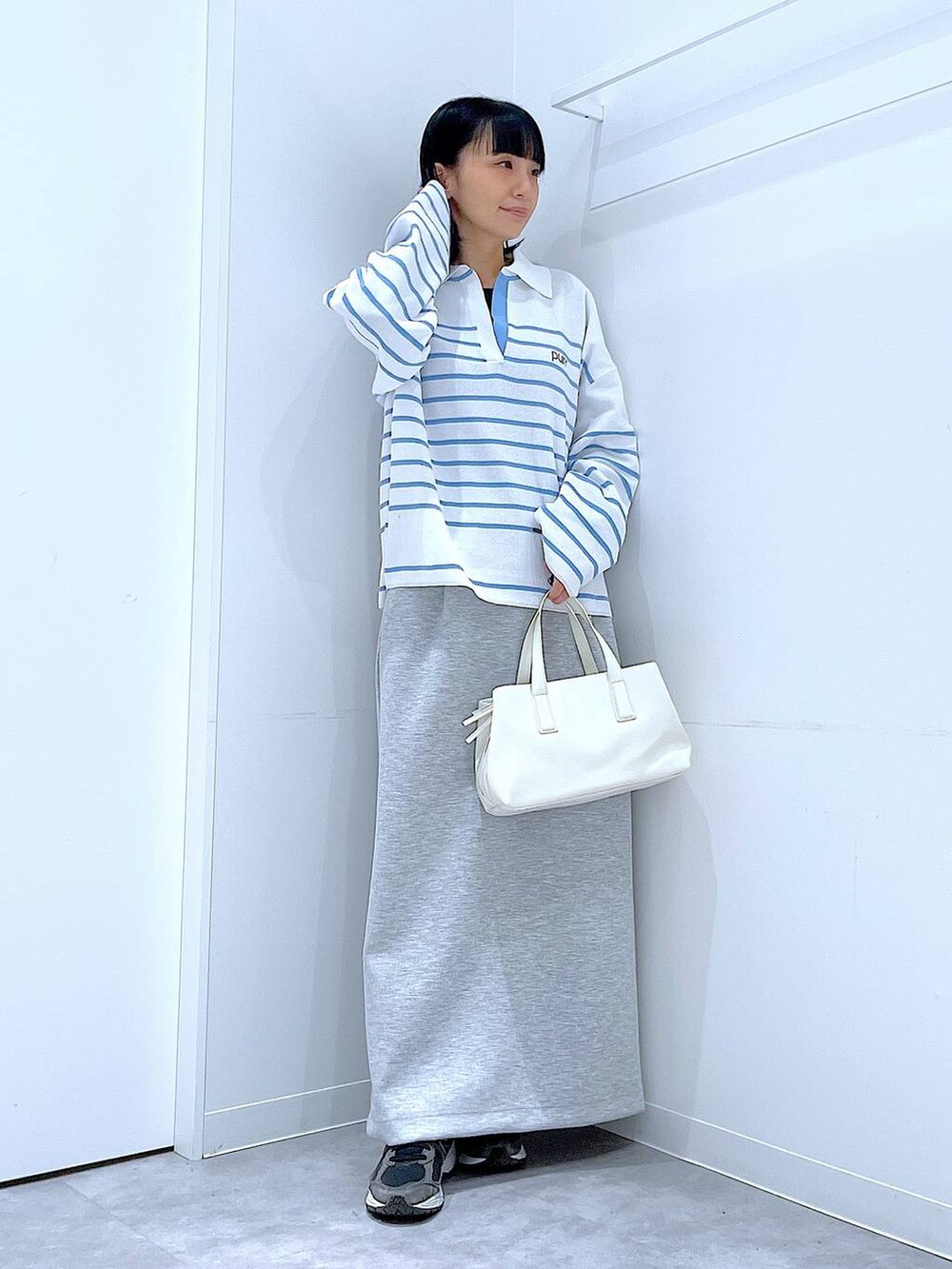 ホワイト系のボストンバッグ、グレー系のスカートを着用したレディースの春コーディネートの2枚目の写真