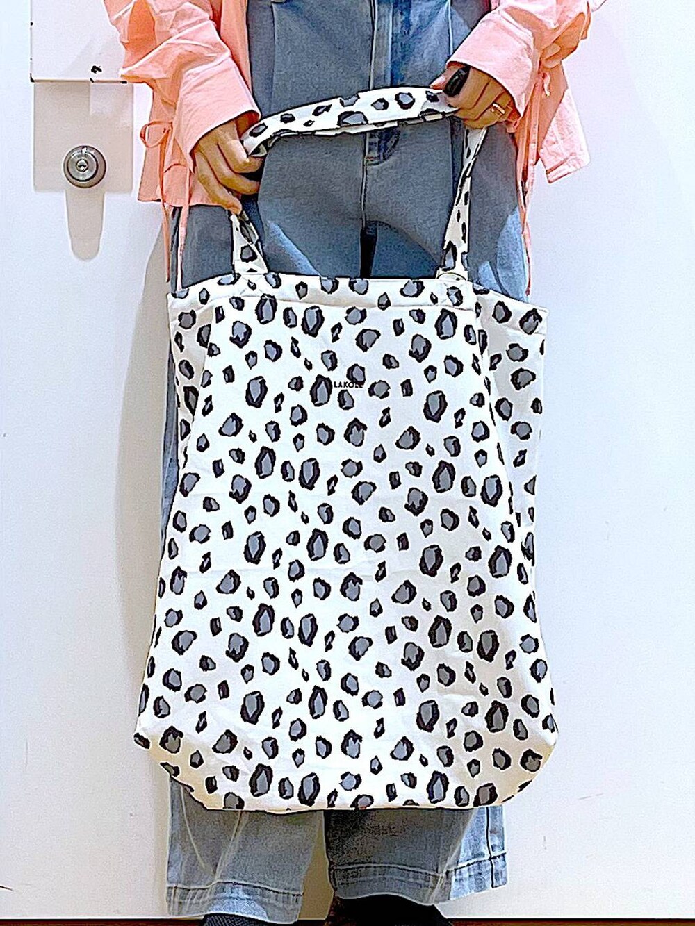 ブルー系のデニムパンツ、ホワイト系のトートバッグ、ピンク系のシャツ/ブラウスを着用したレディースの春コーディネートの9枚目の写真
