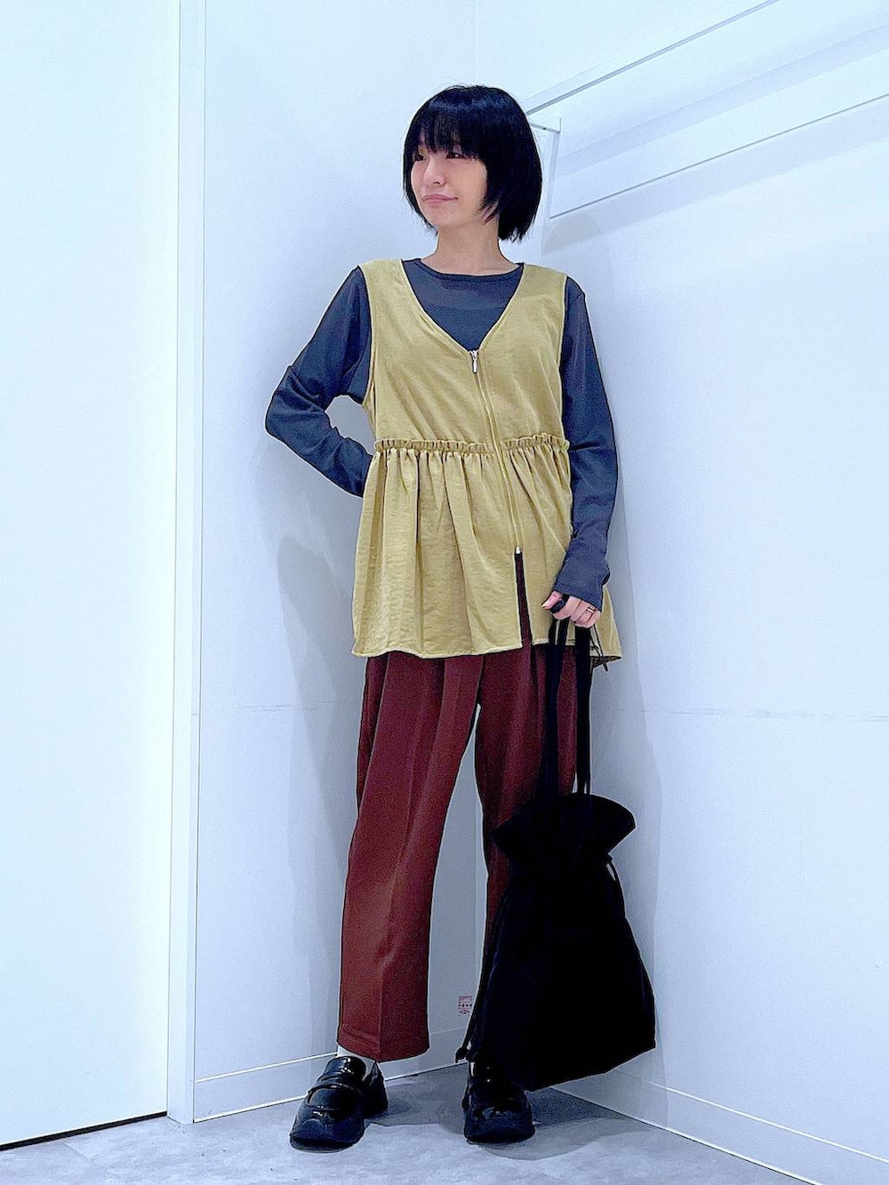 グレー系のTシャツ/カットソー、ブラック系のローファー、ブラック系のトートバッグを着用したレディースの秋コーディネートの2枚目の写真